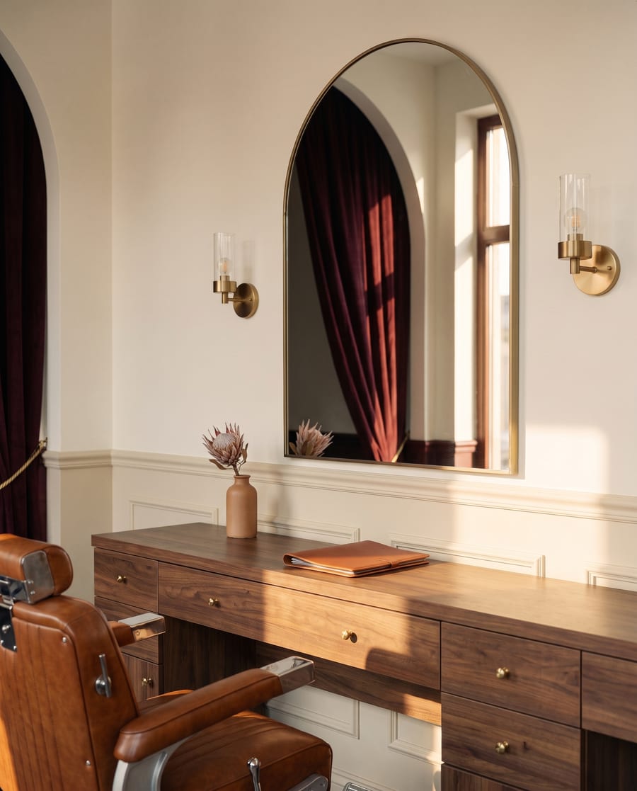 Brass arched mirror and styling station in the empty studio.